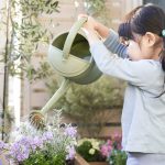 ベランダガーデニングで花に水やりする子供
